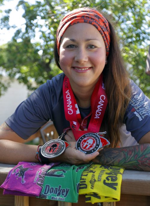 BORIS MINKEVICH / WINNIPEG FREE PRESS Ashleigh Sanduliak poses with some medals and swag from some events she participated in lately. Shes run the Dirty Donkey Mud Run for the last four years and has recently started doing the Spartan mud runs as well.  July 22, 2016