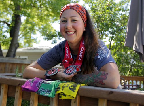 BORIS MINKEVICH / WINNIPEG FREE PRESS Ashleigh Sanduliak poses with some medals and swag from some events she participated in lately. Shes run the Dirty Donkey Mud Run for the last four years and has recently started doing the Spartan mud runs as well.  July 22, 2016