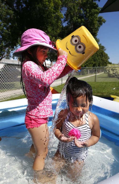 WAYNE GLOWACKI / WINNIPEG FREE PRESS  Five year old Azrielle,right, was visiting her neighbour Riley,3, whose mother had the pool and sprinkler in their front yard on Atlantic Ave. ready for the children to cool off Monday afternoon.    For  Weather story  July 25 2016