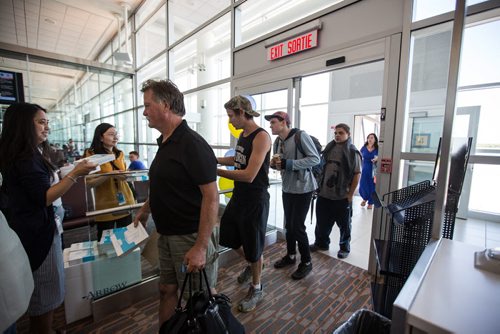 MIKE DEAL / WINNIPEG FREE PRESS The first passengers of first plane to arrive at the Winnipeg Richardson International Airport for Newleaf Travel exit the plane. 160725 - Monday, July 25, 2016