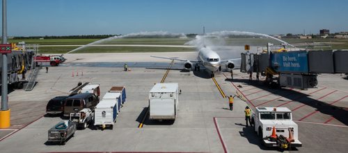 MIKE DEAL / WINNIPEG FREE PRESS As the first plane to arrive at the Winnipeg Richardson International Airport for Newleaf Travel it is greeted with arches of water sprayed from the airports firetrucks as per tradition. 160725 - Monday, July 25, 2016
