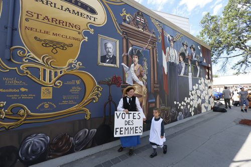 WAYNE GLOWACKI / WINNIPEG FREE PRESS      Genevieve Woods and her daughter Oceana were dressed for the times at the ceremony Tuesday for the unveiling the West End mural remembering the suffragist history titled  A Womans Parliament located at Sargent Ave. and Furby St.  West Ends BIZ organized the unveiling of the mural created  by local artist Mandy Van Leeuwen.        Aidan  Geary story  July 26 2016