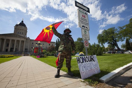 RUTH BONNEVILLE / WINNIPEG FREE PRESS   Chad Reeves with The Urban Warrior Alliance waves a flag near where a small group is camping out  on the Legislative grounds to protest the delays in the MMIW, Murdered and Missing Indigenous Women, inquiry Tuesday.       July 26, 2016