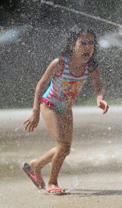 RUTH BONNEVILLE / WINNIPEG FREE PRESS  Five-year-old Arwa Ait El Cadi (proper spelling), cools herself in the sprinklers at Provencher Park Spray Pad Tuesday afternoon while playing with her sisters and friends.   Standup photo  July 26, 2016