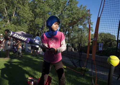 ZACHARY PRONG / WINNIPEG FREE PRESS  Nour Ismael, 10, takes a swing at one of the interactive kiosks demonstrating some of the sports that will be presented at the Canada Summer Games in 2017. Ismael arrived in Winnipeg from Syria two months ago. July 28, 2016.