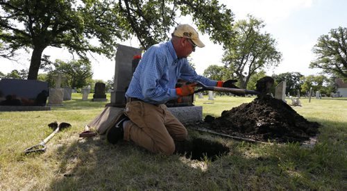 WAYNE GLOWACKI / WINNIPEG FREE PRESS  Danny Jolicoeur the warden of  the St. James Anglican Church cemetery across from Polo Park on Portage Avenue digs a hole for the interment of an urn. Kevin Rollason  story  August 03 2016