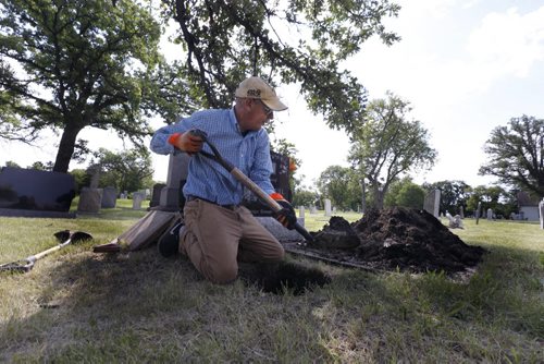 WAYNE GLOWACKI / WINNIPEG FREE PRESS  Danny Jolicoeur the warden of  the St. James Anglican Church cemetery across from Polo Park on Portage Avenue digs a hole for the interment of an urn. Kevin Rollason  story  August 03 2016