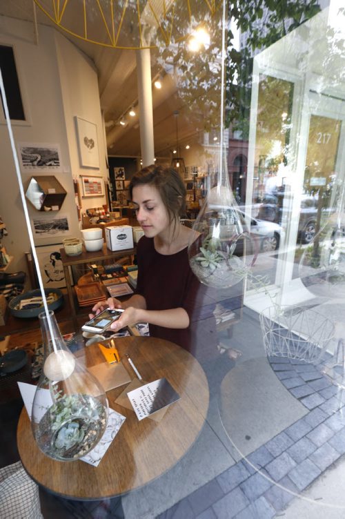 WAYNE GLOWACKI / WINNIPEG FREE PRESS         Danika Bock in the window display of her shop Tiny Feast on McDermot Ave., she uses Instagram to promote her business. Jen Zoratti  story  August 04 2016