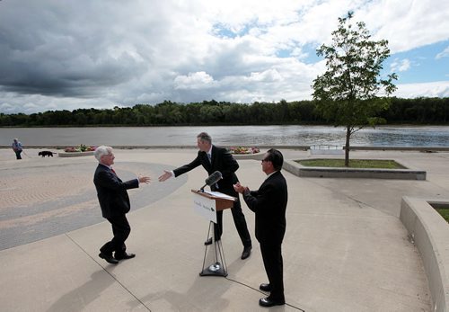 PHIL HOSSACK / WINNIPEG FREE PRESS -  Bridge over troubled waters...With the Red River as a backdrop, Selkirk Mayor Larry Johannson applauds as Federal Minister Jim Carr and Premier Brian Pallister embrace in a handshake to begin a joint endeavor to imrove water quality in the Lake Winnipeg Watershed. See Bill Redekop story. August 5, 2016