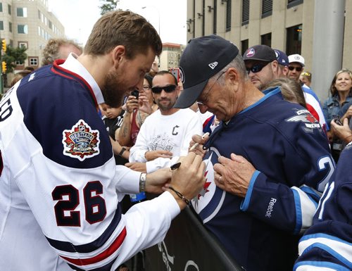 WAYNE GLOWACKI / WINNIPEG FREE PRESS   At the intersection of Portage and Main, Winnipeg Jets player Blake Wheeler wearing the Heritage Classic jersey at the NHL event Friday signs the jersey of Rod Lehmann. Tim Campbell story August 5 2016