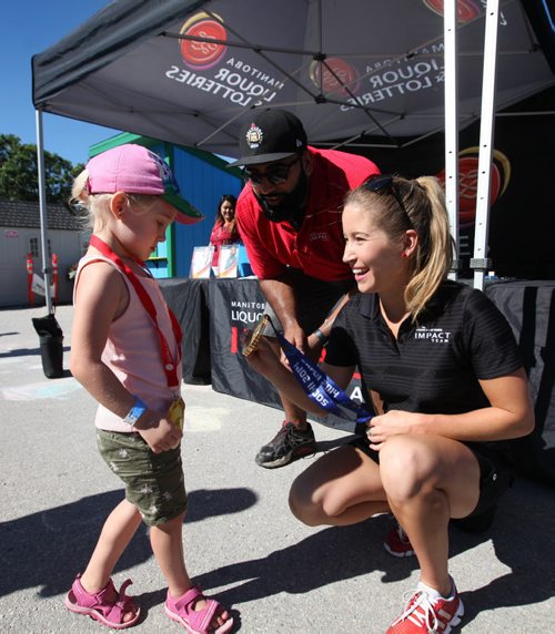 RUTH BONNEVILLE / WINNIPEG FREE PRESS  ZOOOLMYPICS - (standup pix)   Kaitlyn Lawes, Olympic Gold Medallist, Curling, lets 4-year-old Charlie Mayor to check out her official gold medal that she won with her teammates in 2014 Olympics in Sochi at the impact tent with former CFL Football players Obby Khan Saturday.   Each station at the Assiniboine Park Zoo is set up to encourage visitors of all ages to get active like the athletes in Rio in  Activity Circuits which involve fun activities like climbing inflatables and races.   Aug 06, 2016