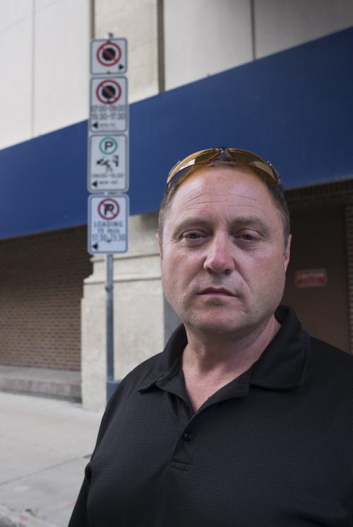 ZACHARY PRONG / WINNIPEG FREE PRESS  Todd Dube of Wise Up Winnipeg, a group that believes the city's traffic ticketing system is unfair and corrupt, in front of parking signs on Donald St. Dube says the signs or unnecessarily confusing and leave too many unsuspecting Winnipegers with hefty fines. August 6, 2016.