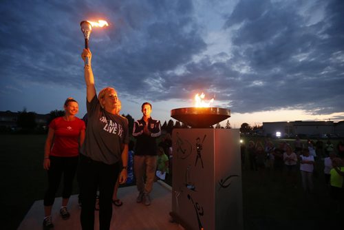JOHN WOODS / WINNIPEG FREE PRESS Michelle Sawatzky Koop lights the caldron at the opening ceremonies of the Manitoba Games in Steinbach, Sunday, August 7, 2016.