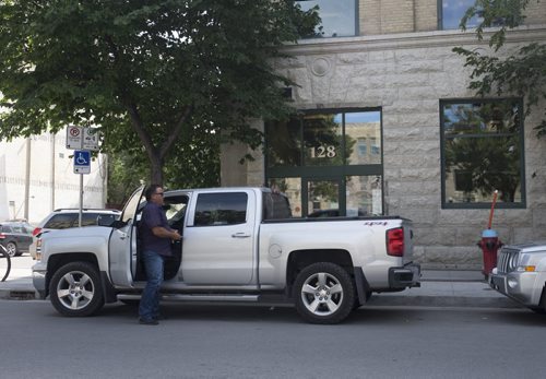 ZACHARY PRONG / WINNIPEG FREE PRESS  Russ Shewchuk exits his truck shortly after parking on Market St. Despite the sign to his left that says he can park in this location, he would in fact be parked illegally and receive a ticket for parking too close to a fire hydrant. August 8, 2016.