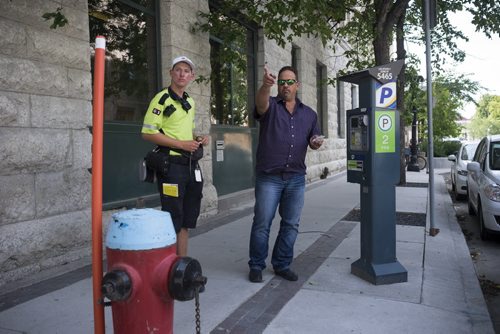 ZACHARY PRONG / WINNIPEG FREE PRESS  Russ Shewchuk argues with a parking enforcement officer who asked not to be named shortly after he parked his car on Market Ave. Despite signs saying paid parking is allowed in this location the officer told Shewchuk he would receive a ticket if he did not move. The officer said he understands the signs are incorrect but that he is still required to give tickets to anyone parked here. August 8, 2016.