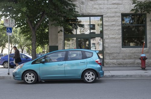 ZACHARY PRONG / WINNIPEG FREE PRESS  A car on Market Ave. stopped in a location that according to the sign on the left is a legal parking space. However anyone caught parking here would receive a ticket for parking too close to the fire hydrant. August 8, 2016.