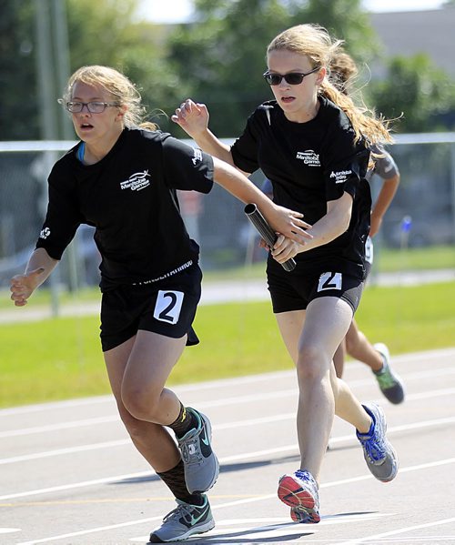 PHIL HOSSACK / WINNIPEG FREE PRESS - Carissa Kennedy t(right) slips the baton into team mate Emma Tomchuk's hand in the women's 4x100 relay Monday at the SUMMER GAMES. SEE Tim Campbell's story.  See story. August 8, 2016