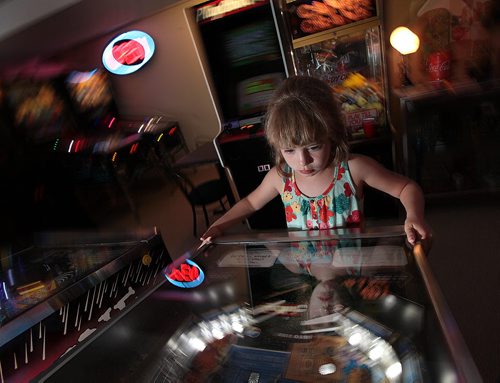 PHIL HOSSACK / WINNIPEG FREE PRESS - 7 yr old Jillian Swanson focuses on a pinball machine in her parent's basement near Selkirk. Eric and Angela Swanson have been collecting pinball machines and arcade memoribilia for years. See Dave Sanderson story. August 8, 2016
