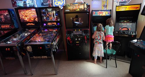 PHIL HOSSACK / WINNIPEG FREE PRESS - 4 yr old Amy (right) and her sister 7 yr old Jillian Swanson focus a video game  machine in her parent's basement near Selkirk. Eric and Angela Swanson have been collecting pinball machines and arcade memoribilia for years. See Dave Sanderson story. August 8, 2016