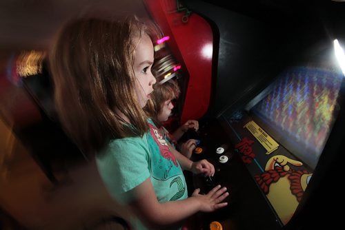 PHIL HOSSACK / WINNIPEG FREE PRESS - 4 yr old Amy (front) and her sister 7 yr old Jillian Swanson focus a video game  machine in her parent's basement near Selkirk. Eric and Angela Swanson have been collecting pinball machines and arcade memoribilia for years. See Dave Sanderson story. August 8, 2016