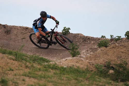 JOHN WOODS / WINNIPEG FREE PRESS Alex Man, assistant coach and course designer, of the Manitoba Cycling mountain bike team makes his way around a berm as the team practices at Bison Butte, a new racing venue in Winnipeg, Tuesday, August 9, 2016.