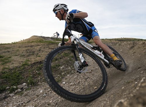 JOHN WOODS / WINNIPEG FREE PRESS coach of the Manitoba Cycling mountain bike team makes his way around a berm as the team practices at Bison Butte, a new racing venue in Winnipeg, Tuesday, August 9, 2016.