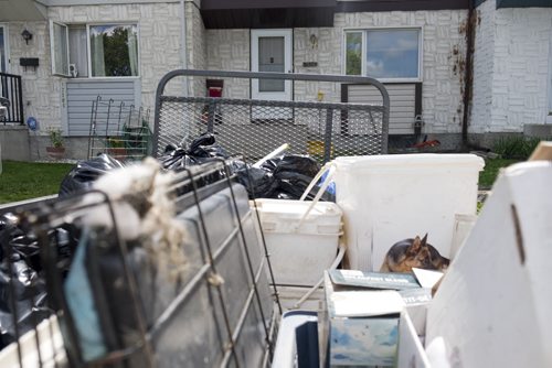 ZACHARY PRONG / WINNIPEG FREE PRESS  A trailer filled with cages, garbage and other items in front of the Valley Gardens townhouse where staff from the province's chief veterinary office and the Winnipeg Humane Society found more than a dozen dogs living in squalid conditions amongst feces and the bodies of rotting puppies. August 10, 2016.