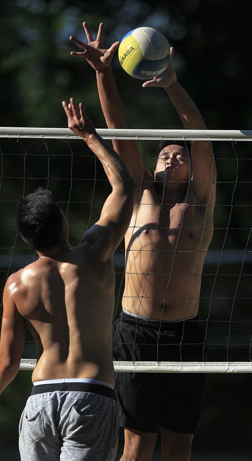 PHIL HOSSACK / WINNIPEG FREE PRESS -  STAND-UP - SHADOW and LIGHT - Bryan Bautista blocks hius buddy Keith Fernandez while playing a little beach volleyball at Assinaboine Park Wednesday evening.  Temps were forcast for highs of 23C Wed but soared over 27C late in the afternoon. The next coupe of days are cool and wet.  August 10, 2016