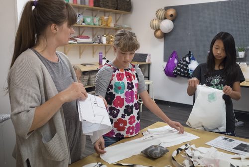 ZACHARY PRONG / WINNIPEG FREE PRESS  Rhonda Wiebe, an instructor at the Sew Fun Studio, helps Abby, 11, and Joanna, 11, with their tote bags at the Sew Fun Studio. August 12, 2016.