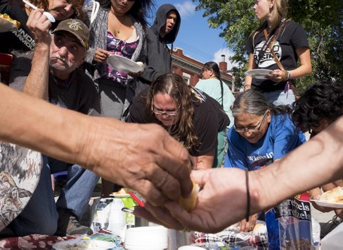 ZACHARY PRONG / WINNIPEG FREE PRESS  People share food after a pipe ceremony at the corner of Main and Jarvis organized by the community's youth. The purpose of the ceremony was to bring hope to people from the community, many of whom have been personally affected by violence, suicide and addiction. August 13, 2016.