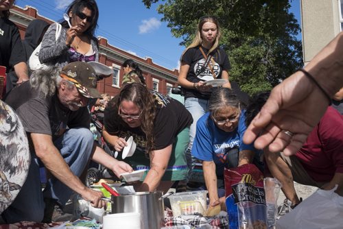 ZACHARY PRONG / WINNIPEG FREE PRESS  People share food after a pipe ceremony at the corner of Main and Jarvis organized by the community's youth. The purpose of the ceremony was to bring hope to people from the community, many of whom have been personally affected by violence, suicide and addiction. August 13, 2016.