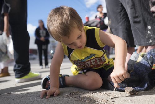 ZACHARY PRONG / WINNIPEG FREE PRESS  Wyatt Primrose, 4, plays on the sidewalk after a pipe ceremony on the corner of Main and Jarvis. August 13, 2016.