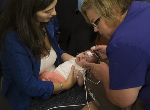 ZACHARY PRONG / WINNIPEG FREE PRESS  Nurse Gail Thompson performs a hearing screening on newborn Camila at the Children's Hospital Research Institute of Manitoba as her mother Anabela Vicente holds her on August 16, 2016. Starting on September 1, 2016, all newborns in Manitoba will receive the screening to detect any hearing problems at birth. Doing so will allow for early intervention that can help prevent or stop developmental problems arising from hearing loss.