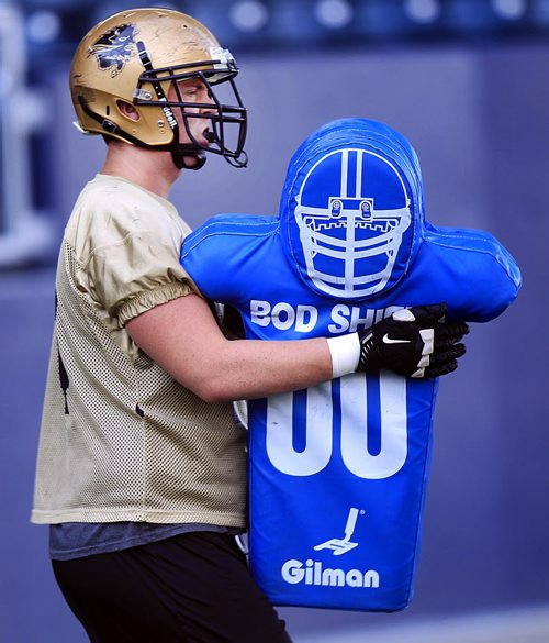 PHIL HOSSACK / WINNIPEG FREE PRESS - Bison offensive lineman Matt Clarkson embraces a "training dummy" at Investors Group Field Tuesday afternoon. See Jason Bell story.  August 16, 2016