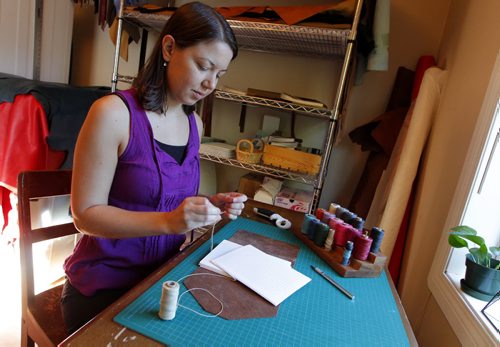 BORIS MINKEVICH / WINNIPEG FREE PRESS Andrea Davis has endometriosis which prevents her from working a regular 9-5 job. She started an Etsy company making hand-bound journals and notebooks that are ethically sourced. Her company is called We Are Bound Together. In this photo Davis works on some of her creations. For Erin Lebar story. August 17, 2016
