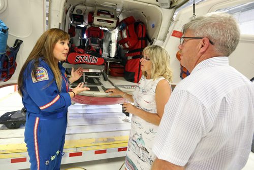 JASON HALSTEAD / WINNIPEG FREE PRESS  L-R: Shock Trauma Air Rescue Society (STARS) flight nurse Sarah Painter shows the helicopter to guests Lynne Guertin and Allan Penner at a fundraising dinner for STARS on Aug. 17, 2016, at the STARS hangar. STARS is a non-profit helicopter air ambulance organization that provides rapid and specialized emergency care and transportation for critically ill and injured patients. (See Social Page)