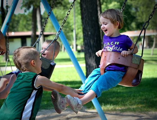 RUTH BONNEVILLE  / WINNIPEG FREE PRESS  Four-year-old Zak Seniuk pushes his sister Kayleigh - 3yrs on the swing as she giggles while playing with his siblings at Kildonan Park Thursday.    Standup photo   Aug 17 / 2016