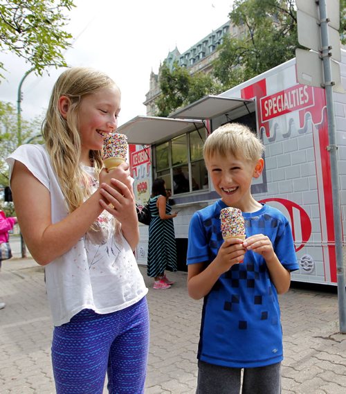 BORIS MINKEVICH / WINNIPEG FREE PRESS Weather photo standup. Juliet Lestition,11, left, and her little bother Alex Lestition,7, right, enjoy some ice cream form the all new BDI mobile truck on Broadway Ave. near Garry Street. Photo taken over the lunch hour. The new mobile BDI truck hit the streets less than a week ago. The owner of the truck says lineups are just as long as the original BDI so far.  August 19, 2016