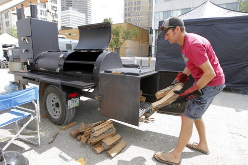 BORIS MINKEVICH / WINNIPEG FREE PRESS The BBQ and Blues Festival kicks off Friday evening. They start setting up today and the cook off is tomorrow (Saturday) The event is in and around the Burton Cummings Theatre with entertainment too. Russ Kihn of Dusty Rusty's BBQ team out of La Broquerie, Manitoba gets his hard wood ready for tomorrows competition. He built the competition BBQ himself. August 19, 2016