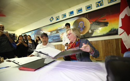 RUTH BONNEVILLE  / WINNIPEG FREE PRESS  Minister Carolyn Bennett and Tadoule Lake Chief Ernie Bussidor sign papers for a large settlement to the Dene people for a forced relocation that took place 60 years ago.  The Minister also made a formal apologies to the people in Tadoule Lake earlier in day and later in Dene Village, near Churchill Manitoba, for the forced move of the Dene people in a formal ceremony Tuesday.   See Alex Paul story.    Aug 16 / 2016