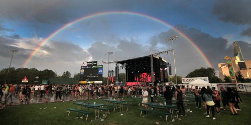PHIL HOSSACK / WINNIPEG FREE PRESS - Electric Sunset - Dancers and the stage at Shaw Park are framed in a full spectrum rainbow Friday evening as participants endure a rainshower at "Electric Sunset". STAND-UP See release?? August 19, 2016
