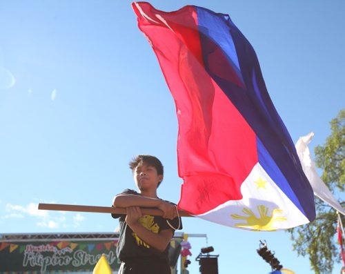RUTH BONNEVILLE  / WINNIPEG FREE PRESS  Thirteen-year-old Ezra Cusimu waves a large Filipino Flag around as he performs with The Winnipeg Sikaran Arnis Academy, a martial arts school in front of the stage on Broadway at the  5th annual Manitoba Filipino Street Festival Saturday.    Aug 19 / 2016
