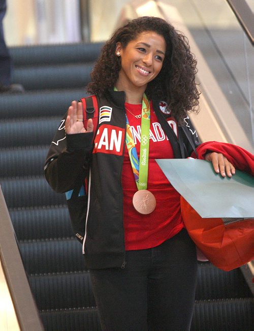 JOE BRYKSA / WINNIPEG FREE PRESS  Team Canadas Desiree Scott / soccer waves with her bronze medal as she arrives home at Richardson International Airport tuesday morning from the Olympics in Rio - Aug 23, 2016