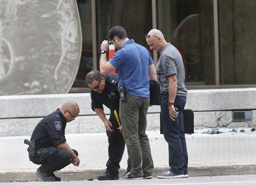 WAYNE GLOWACKI / WINNIPEG FREE PRESS    Police investigate the area of the explosion. Winnipeg Police closed down the intersection of Kennedy St. and York Ave. in front of the Law Courts building Wednesday after a small device exploded by the sculpture. No one was injured. Kristin Annable story August 24 2016