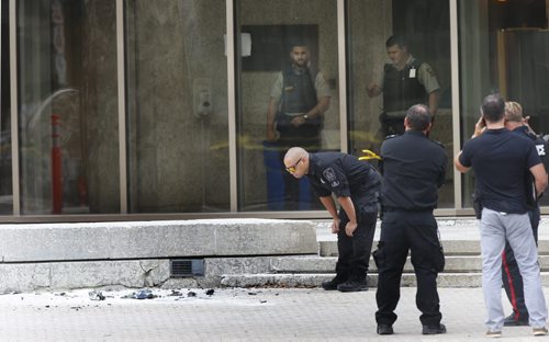WAYNE GLOWACKI / WINNIPEG FREE PRESS    Police at the scene of the explosion Wednesday in front of the Law Courts bld.   Winnipeg Police closed down the intersection of Kennedy St. and York Ave. in front of the Law Courts building Wednesday after a small device exploded by the sculpture. No one was injured. Kristin Annable story August 24 2016