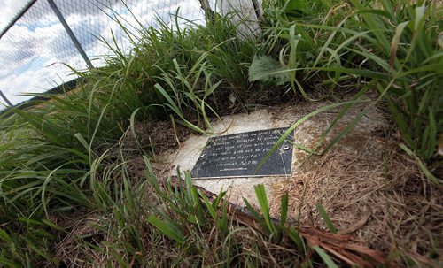 PHIL HOSSACK / WINNIPEG FREE PRESS -  A plaque engraved with a biblical reading rests at the base of  a cruxifix marking the small graveyard from Headingley Goal in the middle of a nearby wheat field. See Bill Redekop's story.  August 24, 2016