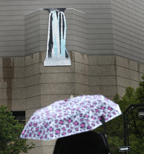 WAYNE GLOWACKI / WINNIPEG FREE PRESS    Waterfall and rain falls Thursday morning. A new public artwork was installed at the Millennium Library this week entitled Waterfall #2  made from outdoor sequins that has the appearance of  shimmering water. It was created by Reykjavik-based Danish artist Theresa Himmer and is on the exterior corner wall of the Millennium Library at Smith and Graham.   The art work is described in the news release as "Waterfall #2, is a full size, mirrored version of Waterfall #1 that was created in response to the cultural and political realities that led to the economic crash of 2008. Within that context, Waterfall #1 playfully investigated the relationship between natural and artificial landscapes, while reflecting critically on the increasing commodification of Icelandic nature. Waterfall #1 in Reykavik was dismantled in the fall of 2014." August 25 2016