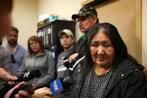 RUTH BONNEVILLE / WINNIPEG FREE PRESS  Norway House resident Frances Tait looks down as she is asked questions by the media about the news of learning her son, David Tait (lbeige hat, rear) was switched at birth at press conference held Friday at Norway House Offices.    Her husband David Tait Sr. behind her in photo.  Aug 26, 2016