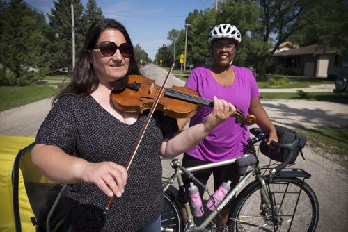 ZACHARY PRONG / WINNIPEG FREE PRESS  Patti Kusturok, left, a renowned fiddler and instructor, with Jasmine Reese, an LA native who is currently completing a bike trip around the world with her dog Fiji. Reese is a classical violin player and while passing through Winnipeg she met with Kusturok for fiddling lessons. August 26, 2016.