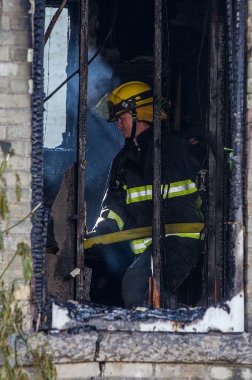 MIKE DEAL / WINNIPEG FREE PRESS A firefighter puts out the last of the fire inside the house that was gutted at 337 Selkirk Avenue early Sunday morning.  20160828 - Sunday August 28, 2016